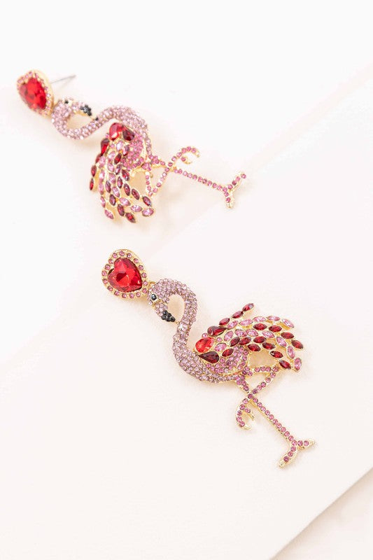 The Pink Flamingo Drop Earrings, featuring pink rhinestones and heart-shaped red studs with jeweled accents, add a charming flair of summer style against a white background.