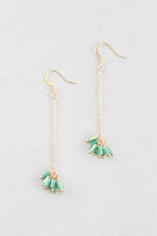 The Palm Dangle Earrings, featuring gold hooks with dangling chains and geometric designs, exude a touch of brass jewelry elegance.