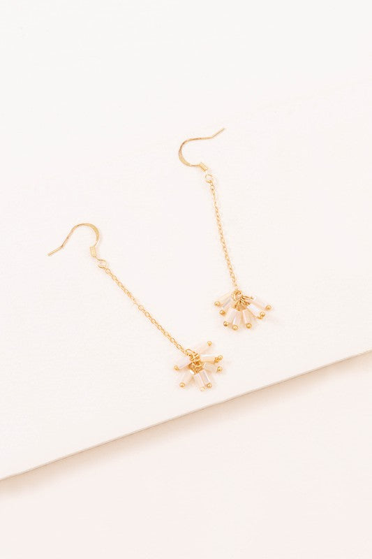 The Palm Dangle Earrings, featuring gold hooks with dangling chains and geometric designs, exude a touch of brass jewelry elegance.