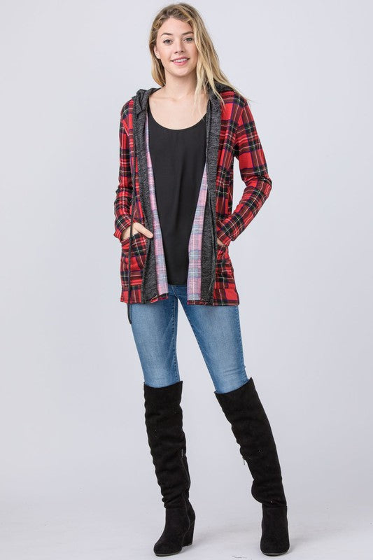 A person is wearing a Hooded Plaid Trimmed Cardigan over a black shirt and blue jeans, standing against a plain background.