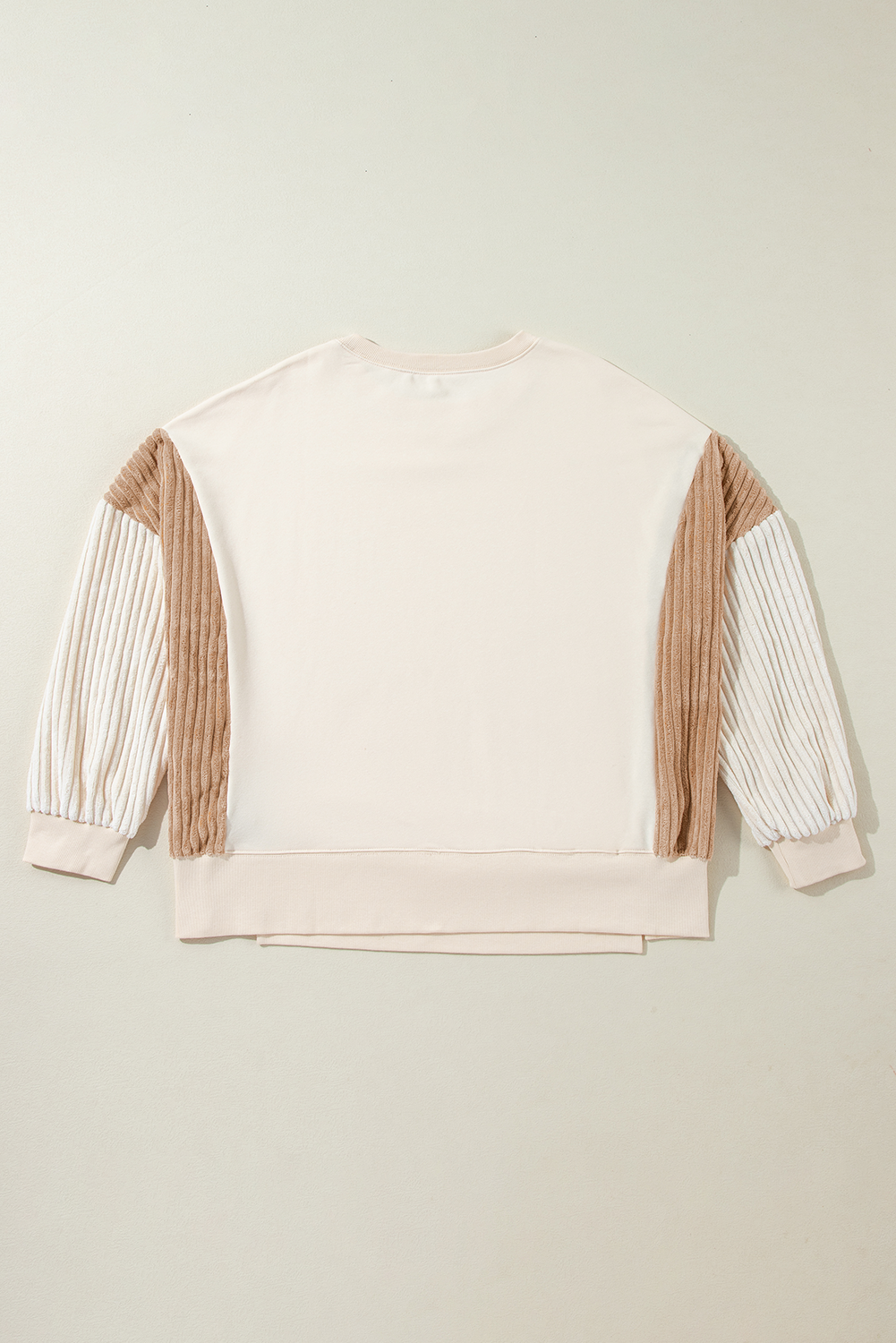 A person with long hair is wearing an Apricot Corduroy Patchwork Drop Shoulder Long Sleeve Sweatshirt, standing with their back to the camera against a light blue corrugated metal wall.