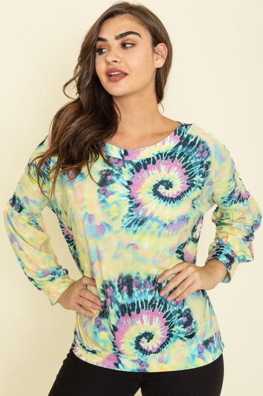 A person wearing the Boat Neck Swirl Tie Dye Tunic, featuring a vibrant spiral pattern against a plain background. Made in the United States, this eye-catching piece is both stylish and unique.