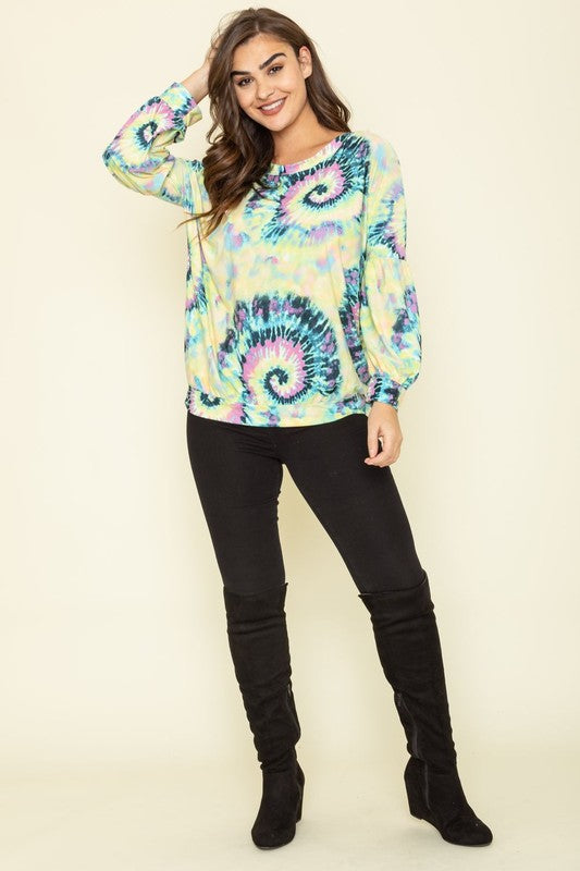 A person wearing the Boat Neck Swirl Tie Dye Tunic, featuring a vibrant spiral pattern against a plain background. Made in the United States, this eye-catching piece is both stylish and unique.