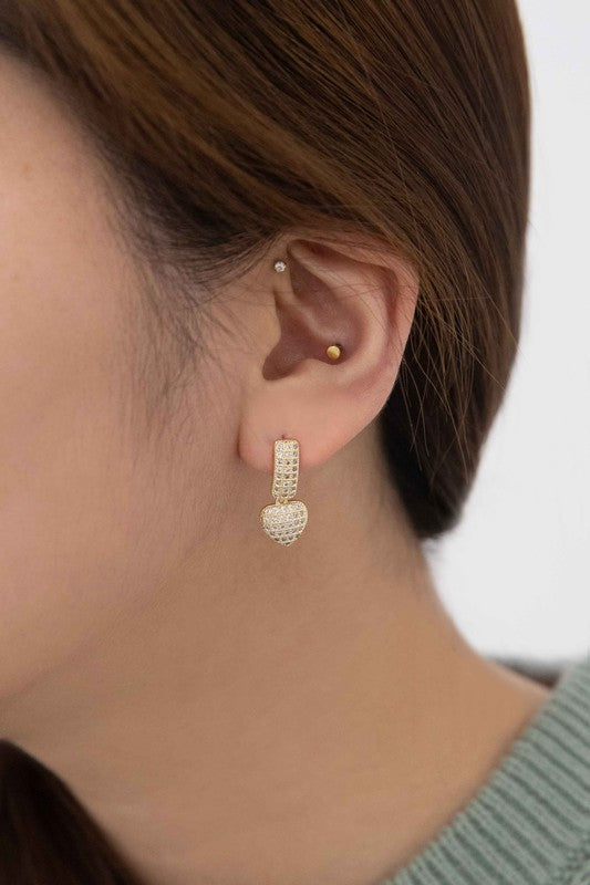 A pair of Amour Drop Earrings with pave set crystals on a light background, featuring 14k gold plating.
