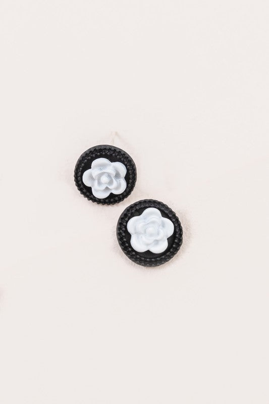 A pair of Noir Rose Stud Earrings with a black border and a white floral design in the center, crafted from Sterling Silver.