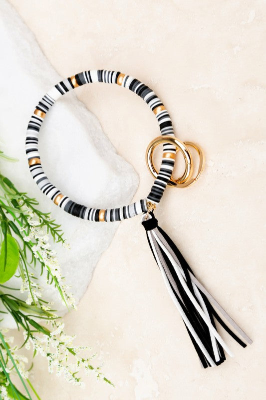 Woman with a Boho Key Ring Bracelet featuring gold wood accent beads, holding a car key.