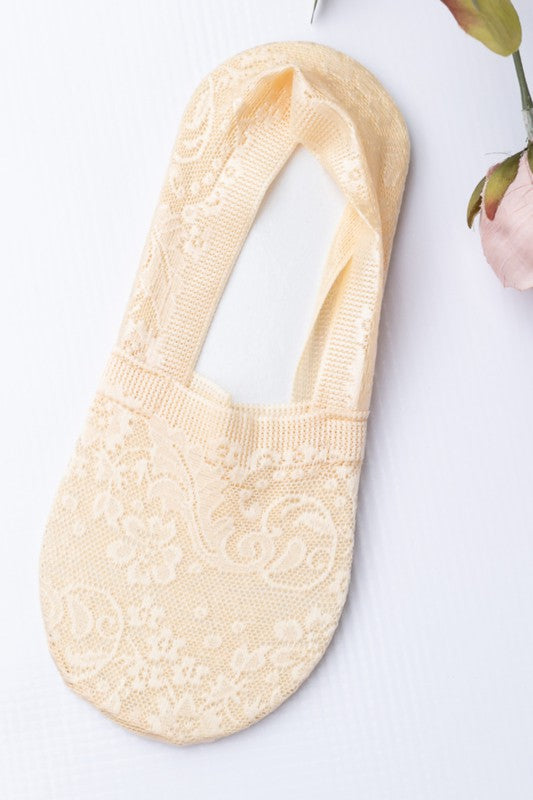 Close-up of a person's feet wearing No-Slip Floral Lace Socks with a small tattoo visible on the ankle against a white background.