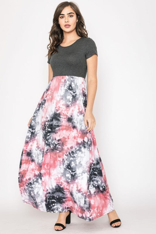 A woman in a gray top stylishly pairs her vibrant Two Tone Tie Dye Maxi Dress, standing against a plain background.