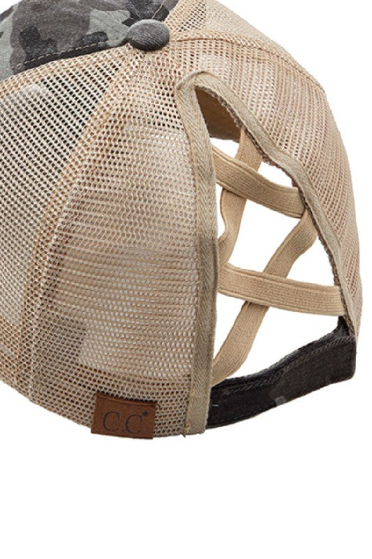 Woman wearing a black mesh CC Camo Criss-Cross Ponytail Cap with an adjustable velcro closure.