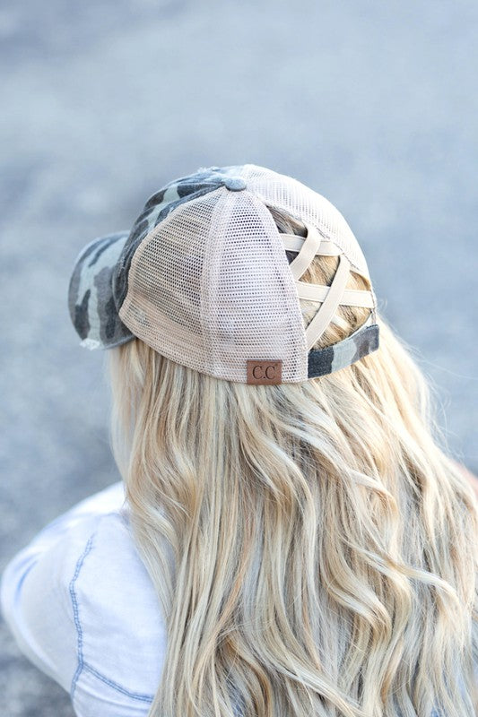 Woman wearing a black mesh CC Camo Criss-Cross Ponytail Cap with an adjustable velcro closure.