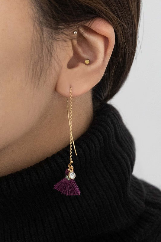 The Keely Tassel Threader Earrings, showcasing vibrant purple tassels and small crystal accents, are displayed on a light background, making them perfect for adding a touch of casual style to any outfit.