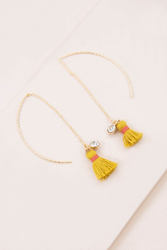 The Keely Tassel Threader Earrings, showcasing vibrant purple tassels and small crystal accents, are displayed on a light background, making them perfect for adding a touch of casual style to any outfit.