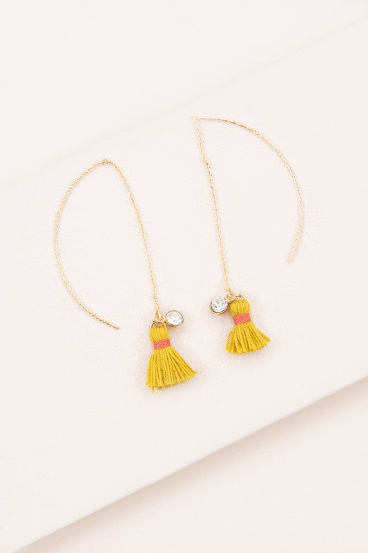 The Keely Tassel Threader Earrings, showcasing vibrant purple tassels and small crystal accents, are displayed on a light background, making them perfect for adding a touch of casual style to any outfit.