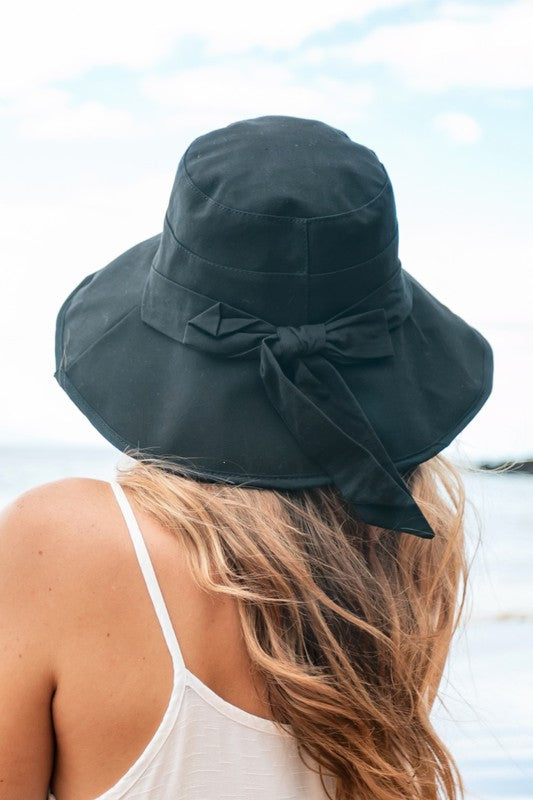 Woman wearing a wide-brimmed Bow Accent Cargo Hat at the beach.