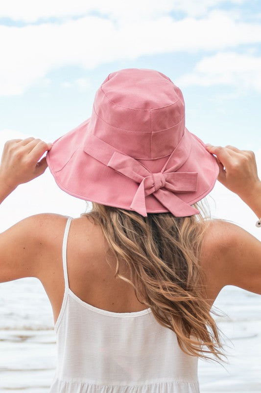 Woman wearing a wide-brimmed Bow Accent Cargo Hat at the beach.