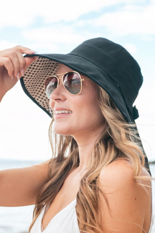 Woman wearing a wide-brimmed Bow Accent Cargo Hat at the beach.