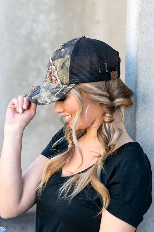 Woman wearing a CC Mossy Oak Baseball Cap Hat with adjustable velcro, looking to the side.