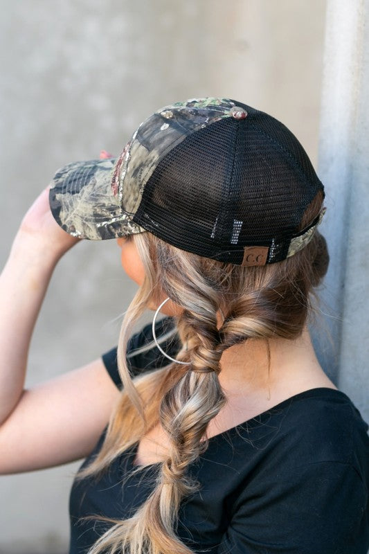 Woman wearing a CC Mossy Oak Baseball Cap Hat with adjustable velcro, looking to the side.