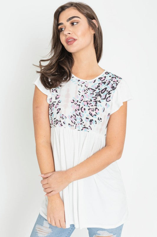 The woman models the Flutter Sleeve Leopard Panel Tunic, featuring a vibrant leopard panel design across the chest and chic flutter sleeves, set against a white background.