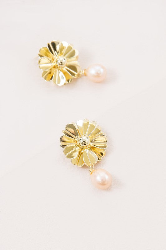 Flora Drop Earrings in 14k gold plating showcase delicate golden petal motifs with sophisticated pearl drop pendants, set against a light background.