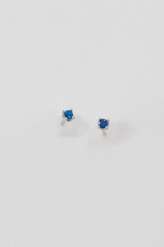 A collection of six pairs of Dainty Stud Stone Earrings displayed on a white background, showcasing hypoallergenic designs with sterling silver accents, adorned with stones in blue, pink, and clear hues.