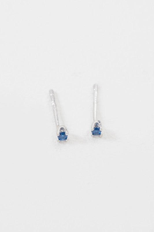 A collection of six pairs of Dainty Stud Stone Earrings displayed on a white background, showcasing hypoallergenic designs with sterling silver accents, adorned with stones in blue, pink, and clear hues.