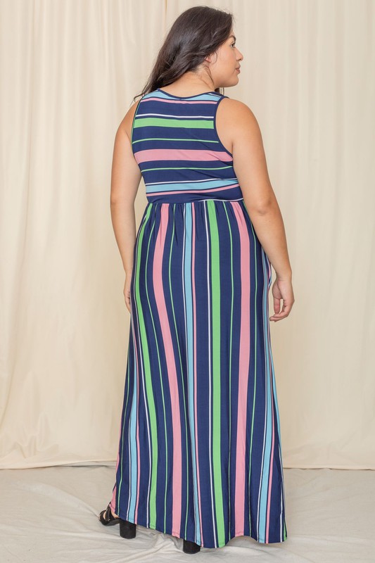 Someone is standing against a light-colored backdrop, wearing the Multi Stripe Rainbow Maxi Dress, a sleeveless garment featuring vertical stripes in shades of blue, green, pink, and purple.