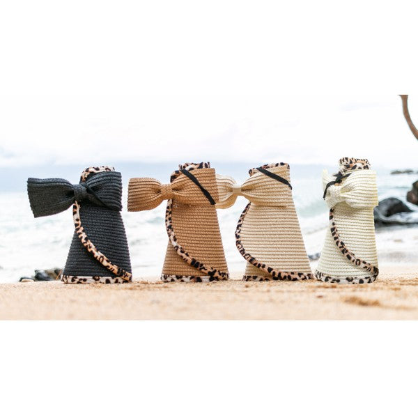 Woman holding her Leopard Foldable Bow Visor, looking out to the sea.