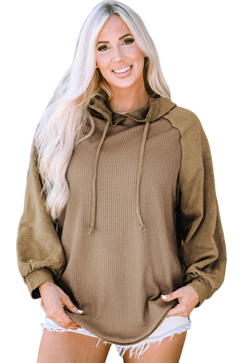 A person with long blonde hair stands facing away from the camera, wearing a trendy Khaki Waffled Expose Seam Drawstring Hoodie.