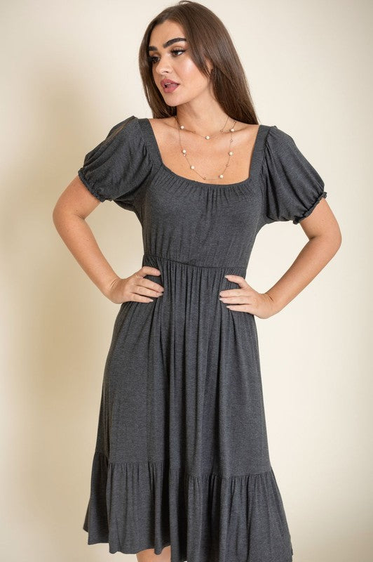 A woman in a Square Neck Puff Sleeve Boho Dress stands against a light background, smiling with her long hair down and wearing high heel sandals.