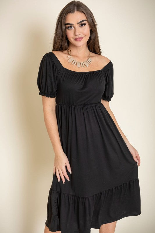 A woman in a Square Neck Puff Sleeve Boho Dress stands against a light background, smiling with her long hair down and wearing high heel sandals.