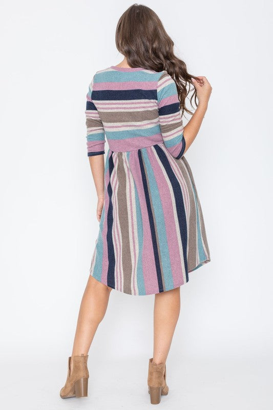 A woman is dressed in the Stripe Curved Hem Midi Dress, made from a polyester-spandex blend and showcasing three-quarter sleeves, standing against a plain white background. This dress, made in the United States, seamlessly blends style with comfort.