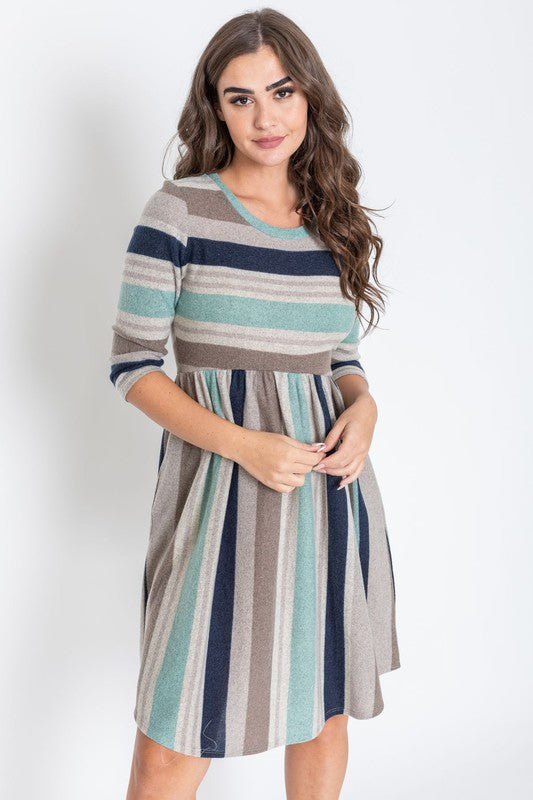 A woman is dressed in the Stripe Curved Hem Midi Dress, made from a polyester-spandex blend and showcasing three-quarter sleeves, standing against a plain white background. This dress, made in the United States, seamlessly blends style with comfort.