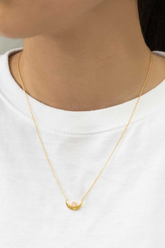 The Rumi Stone Necklace collection showcases five Bohemian-style stone and gold necklaces with crescent-shaped pendants, each adorned with a uniquely colored stone, beautifully displayed on a white background.