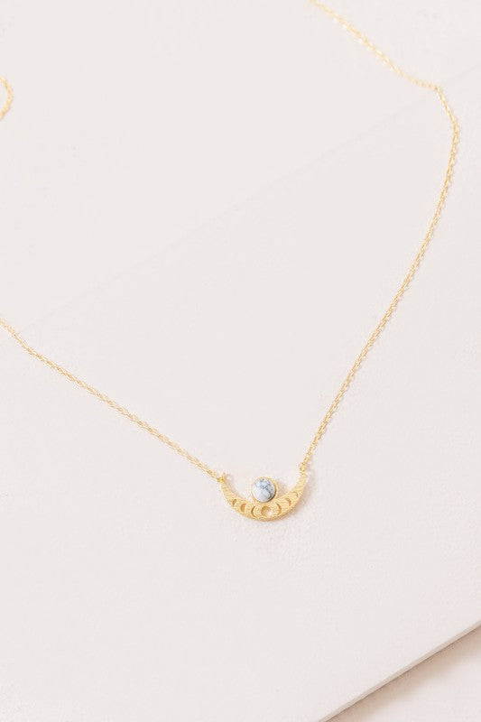 The Rumi Stone Necklace collection showcases five Bohemian-style stone and gold necklaces with crescent-shaped pendants, each adorned with a uniquely colored stone, beautifully displayed on a white background.