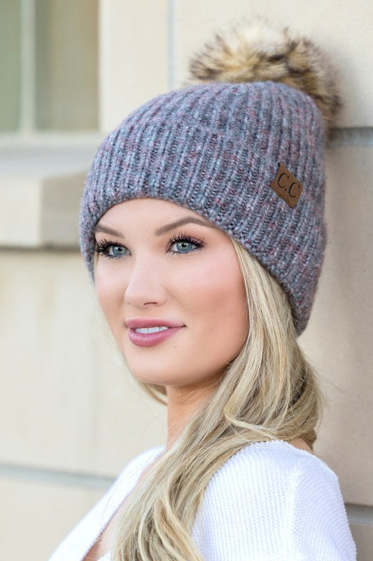 Woman smiling while wearing a CC Cozy Marled Pom Beanie.