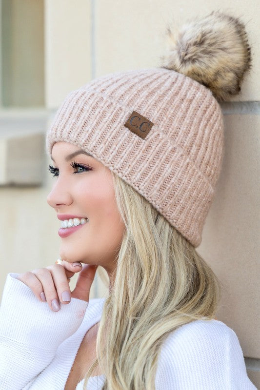 Woman smiling while wearing a CC Cozy Marled Pom Beanie.
