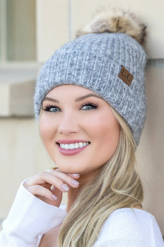 Woman smiling while wearing a CC Cozy Marled Pom Beanie.