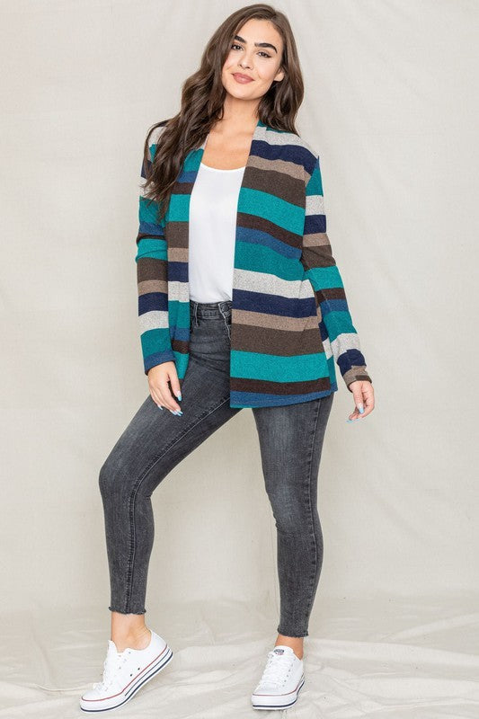 Dressed in a vibrant Stripe Elbow Patch Cardigan composed of soft spandex and polyester, paired with a white top and jeans, an individual stands against a light background.