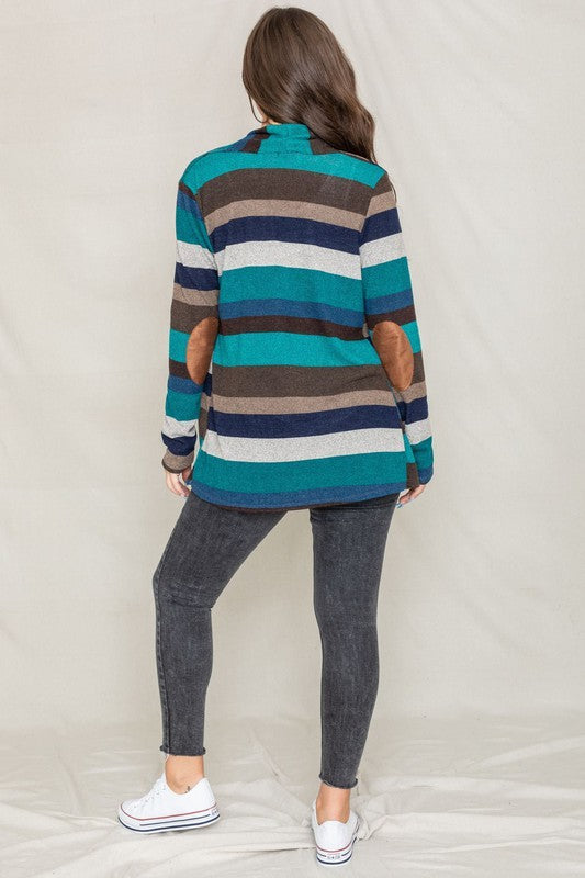 Dressed in a vibrant Stripe Elbow Patch Cardigan composed of soft spandex and polyester, paired with a white top and jeans, an individual stands against a light background.