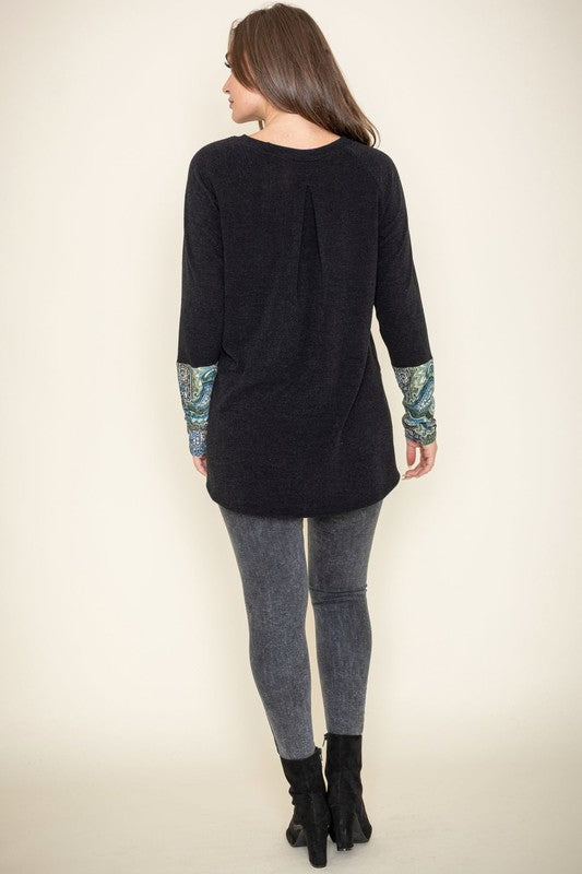 Person wearing a Knit Side Slit Paisley Cuff Tunic with jeans, standing against a plain background.