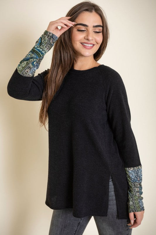 Person wearing a Knit Side Slit Paisley Cuff Tunic with jeans, standing against a plain background.