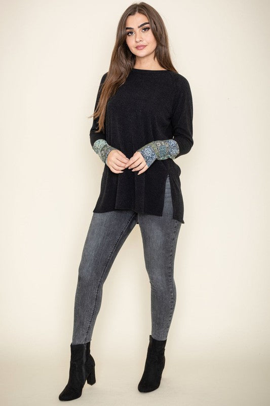 Person wearing a Knit Side Slit Paisley Cuff Tunic with jeans, standing against a plain background.