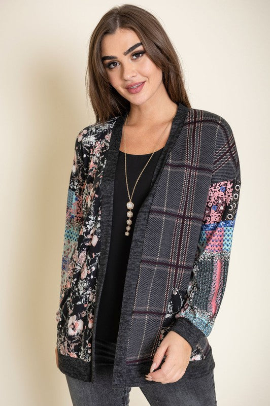 A woman wearing the Mix Fabric Open Cardigan over a black top stands against a neutral background, smiling slightly.