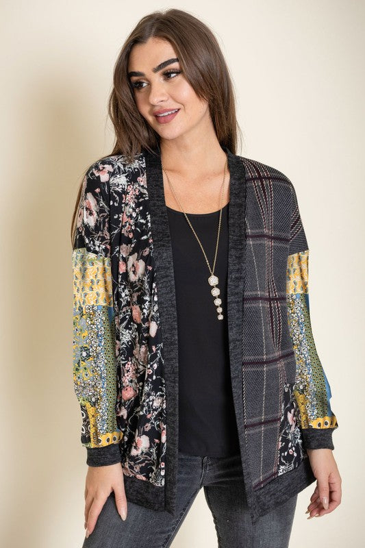 A woman wearing the Mix Fabric Open Cardigan over a black top stands against a neutral background, smiling slightly.