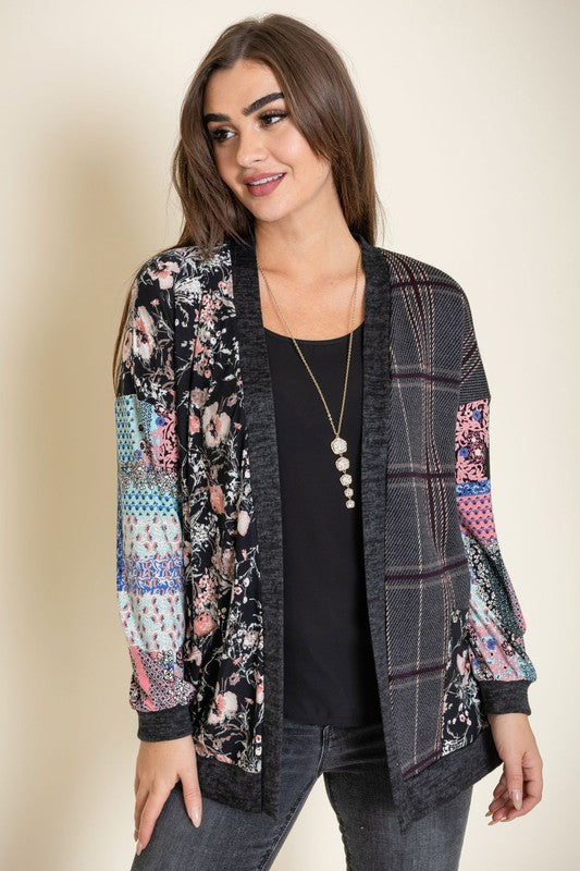 A woman wearing the Mix Fabric Open Cardigan over a black top stands against a neutral background, smiling slightly.