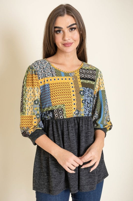 A woman with long dark hair poses against a plain background, wearing a 3/4 Sleeve Quilted Pattern Tunic which features a quilted design and a gray lower half.