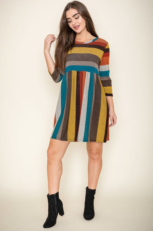 A woman is wearing the Multi Color Mini Dress, crafted from polyester spandex with long sleeves. She is looking off to the left. Made in the United States.