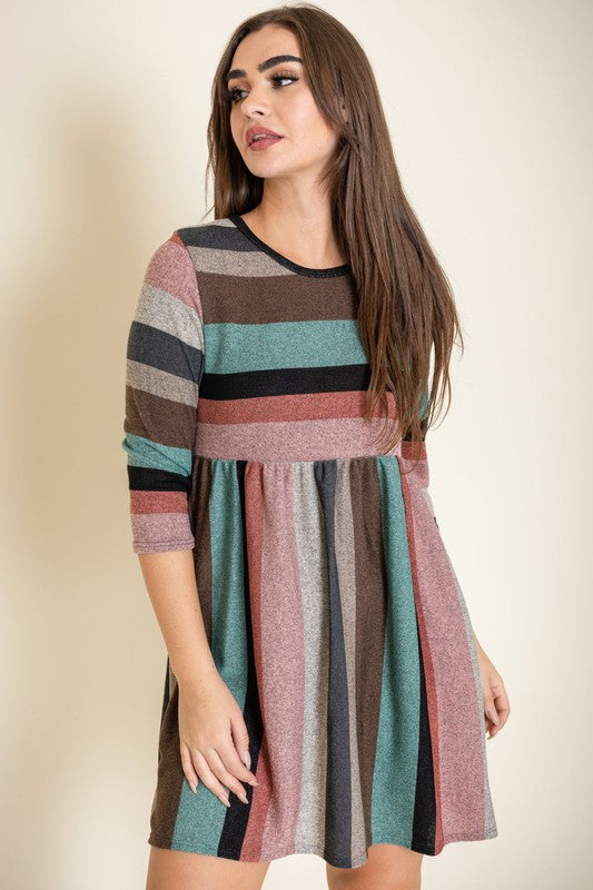 A woman is wearing the Multi Color Mini Dress, crafted from polyester spandex with long sleeves. She is looking off to the left. Made in the United States.