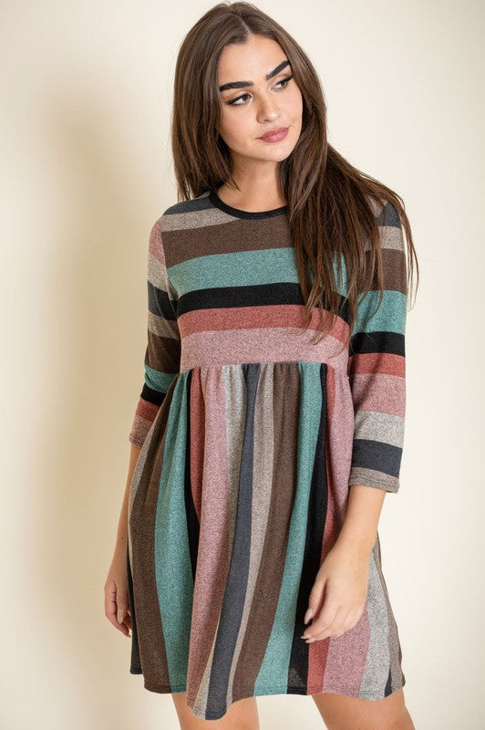 A woman stands against a plain background wearing the Multi Color Mini Dress, crafted from a comfortable blend of polyester and spandex.